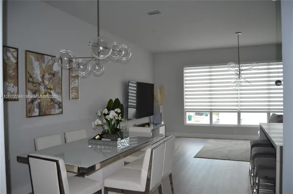 a dining room with furniture and a chandelier