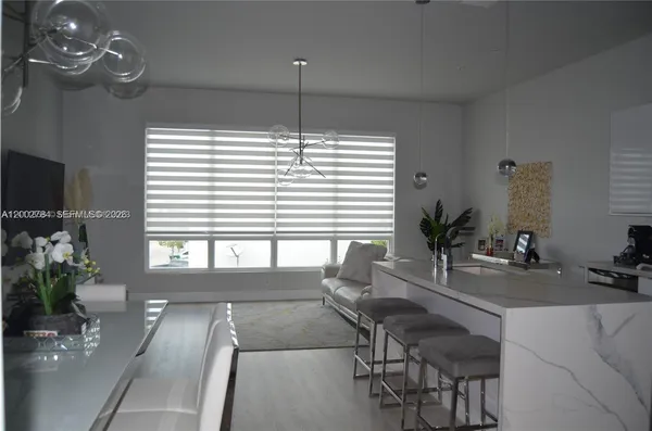 a living room with furniture kitchen view and a chandelier