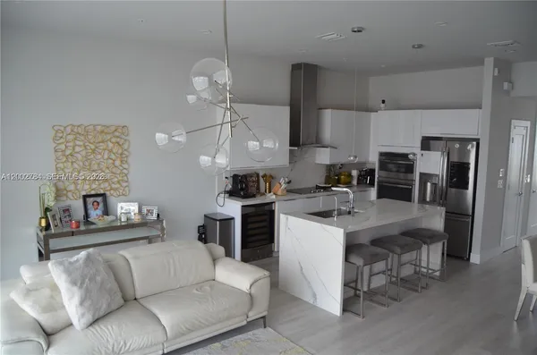 a open kitchen with stainless steel appliances granite countertop a refrigerator and a stove top oven