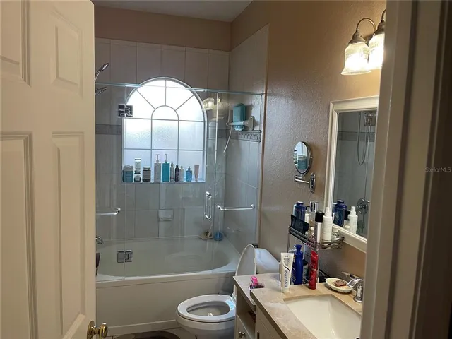 a bathroom with a sink mirror toilet and bathtub