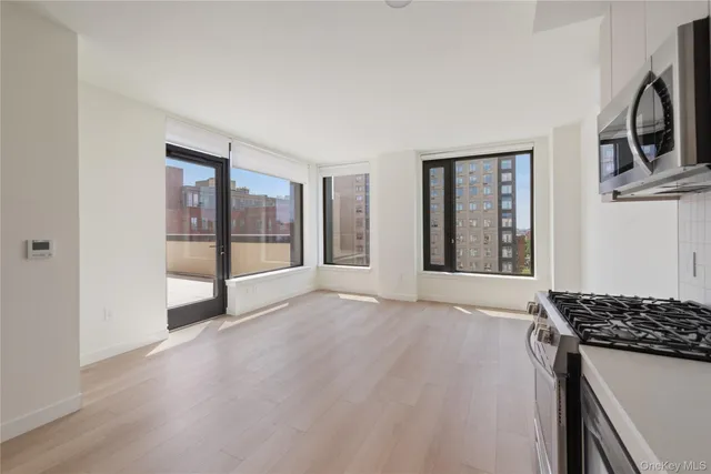 a view of a kitchen with a sink a fridge and wooden floor