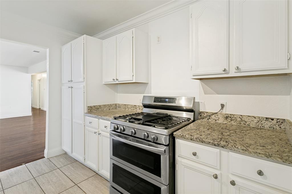 1904 Old Kirk Road Bedford, TX 76022 - Photo 11 of 25 a kitchen with granite countertop white cabinets and appliances