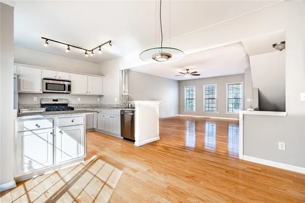 a kitchen with granite countertop a stove a sink and a refrigerator