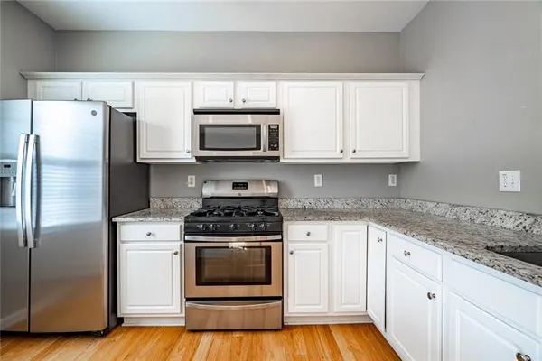 a kitchen with white cabinets stainless steel appliances and a sink