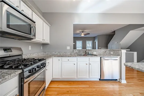a kitchen with stainless steel appliances granite countertop a stove and a microwave