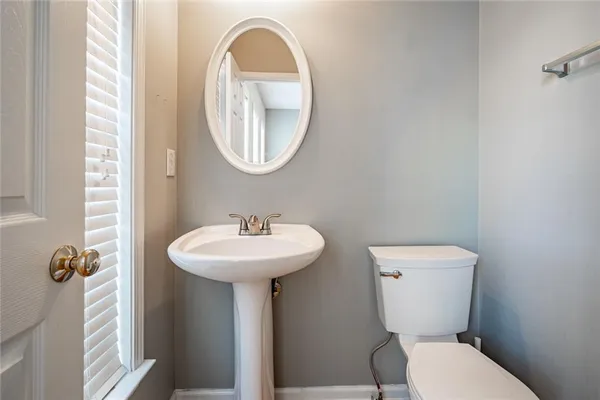 a bathroom with a toilet a sink and a mirror
