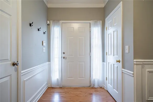 a view of a hallway with wooden floor and closet area