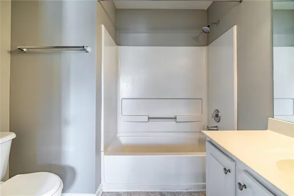 a bathroom with a granite countertop sink mirror vanity and toilet