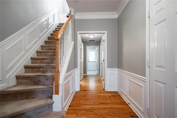 a view of a hallway with wooden floor and entryway