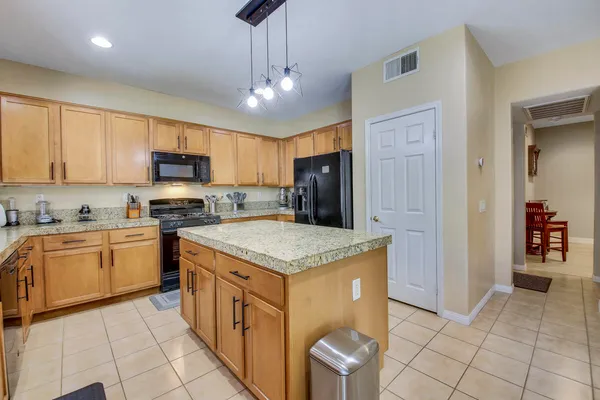 a kitchen with granite countertop a sink a counter top space and cabinets