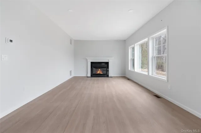 an empty room with a fireplace and windows