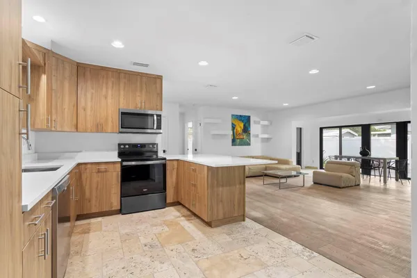 a large kitchen with kitchen island a sink stainless steel appliances and cabinets