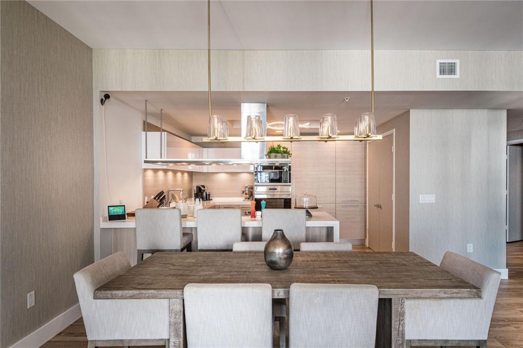 17111 Biscayne Boulevard North Miami Beach, FL 33160 - Photo 24 of 37 a kitchen with a table chairs and white cabinets