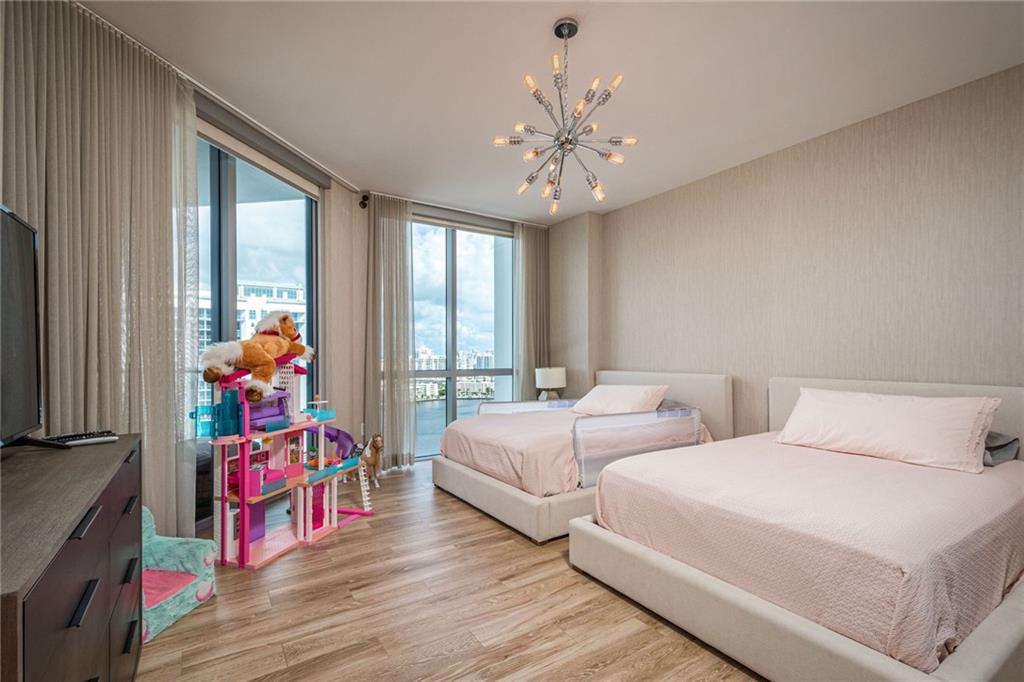 17111 Biscayne Boulevard North Miami Beach, FL 33160 - Photo 32 of 37 a bed room with two beds and a chandelier