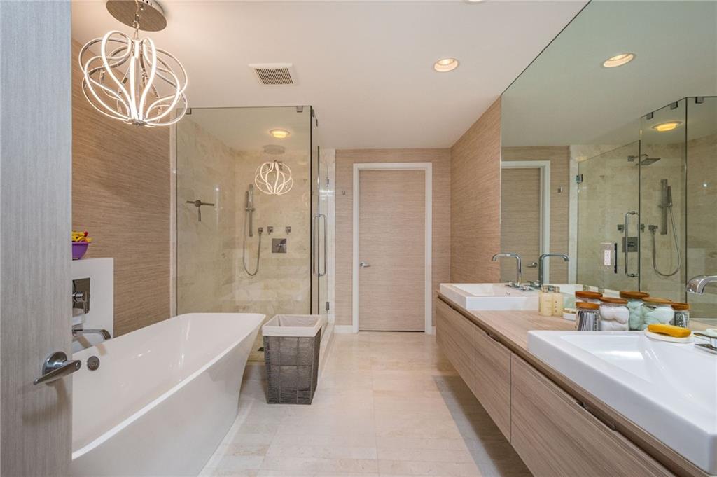 17111 Biscayne Boulevard North Miami Beach, FL 33160 - Photo 33 of 37 a bathroom with a tub a sink and a large mirror