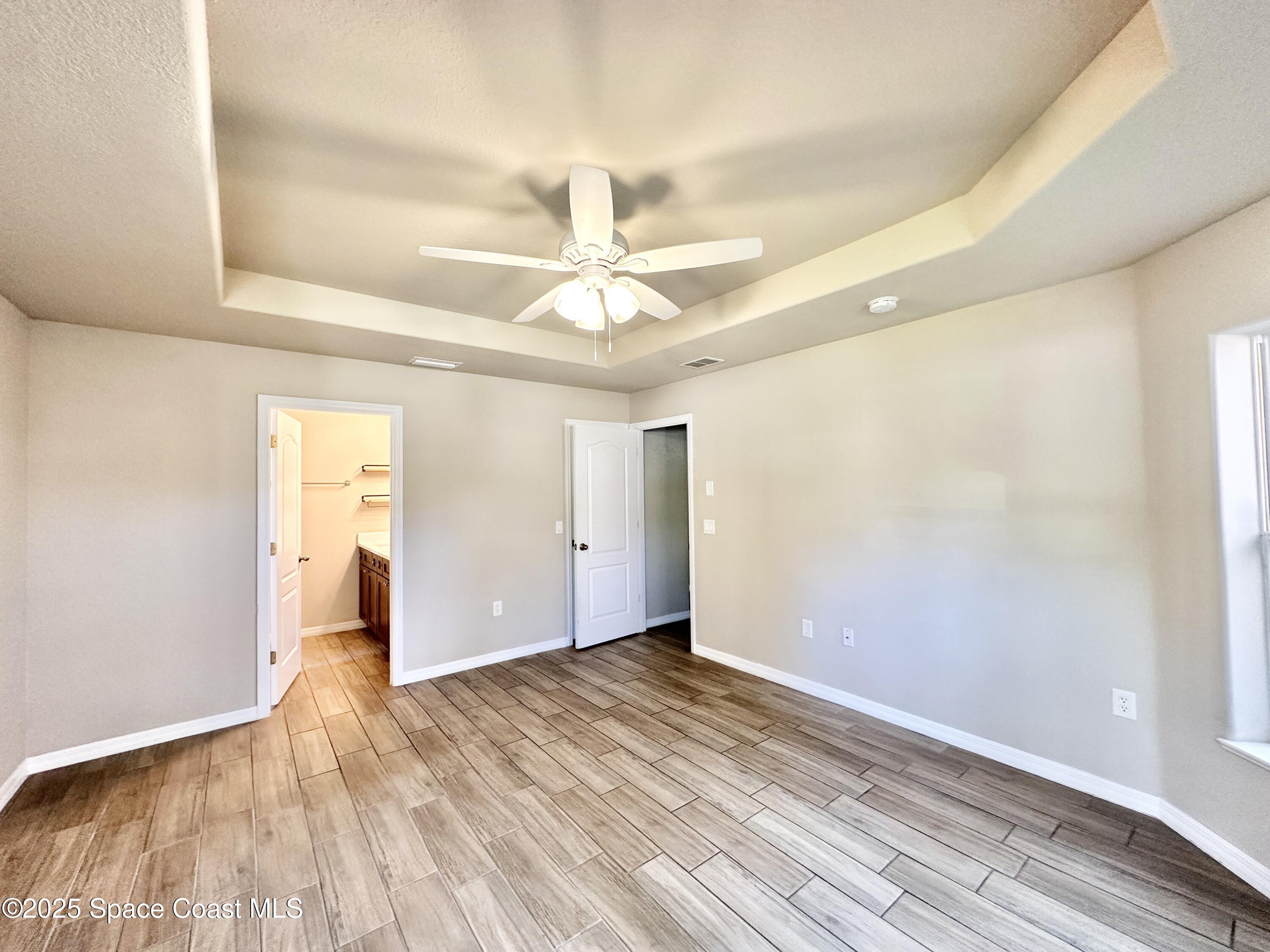 449 Alison Street Titusville, FL 32780 - Photo 11 of 22 a view of an empty room and window and wooden floor