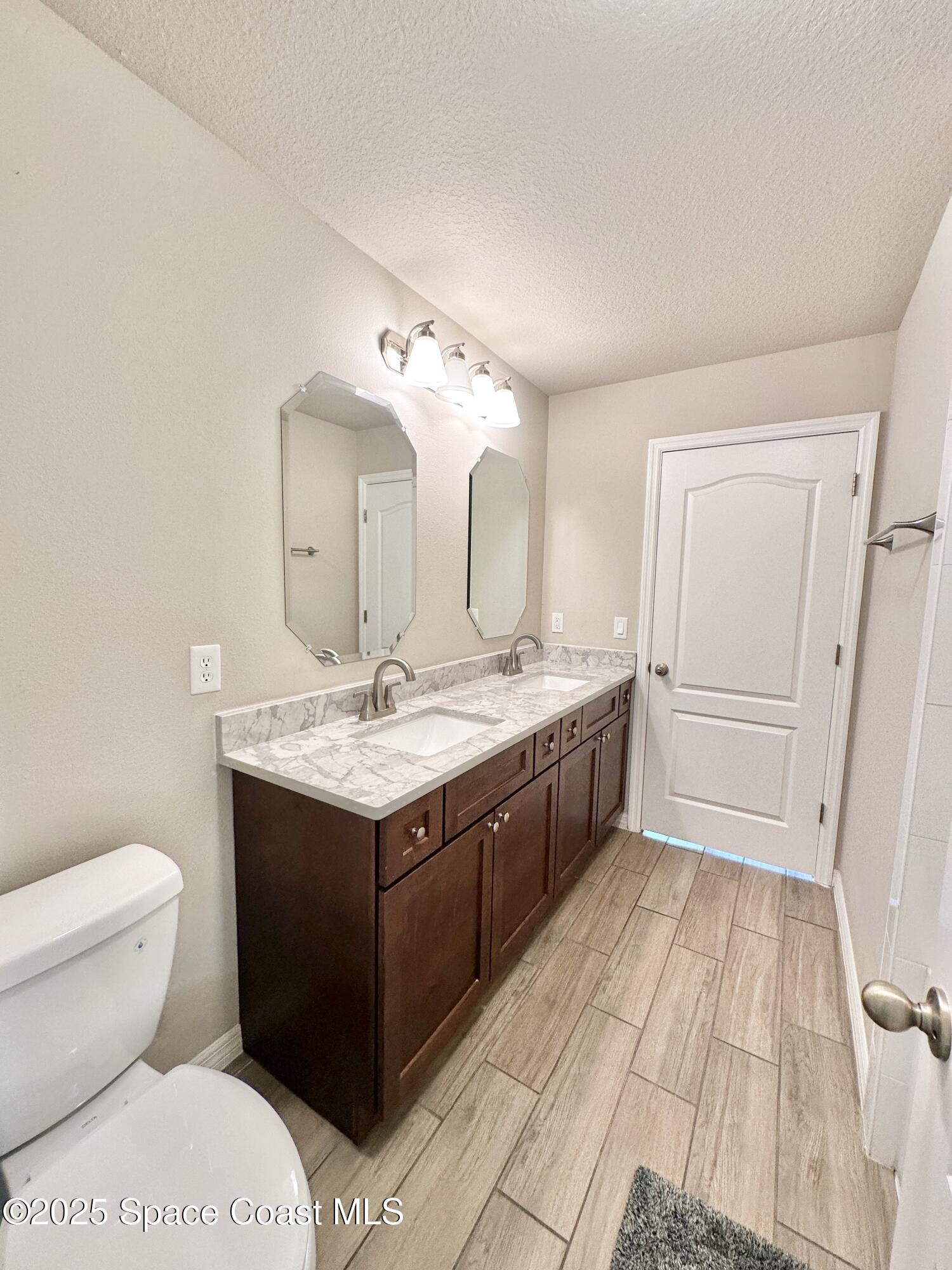 449 Alison Street Titusville, FL 32780 - Photo 15 of 22 a bathroom with a double vanity sink mirror and toilet