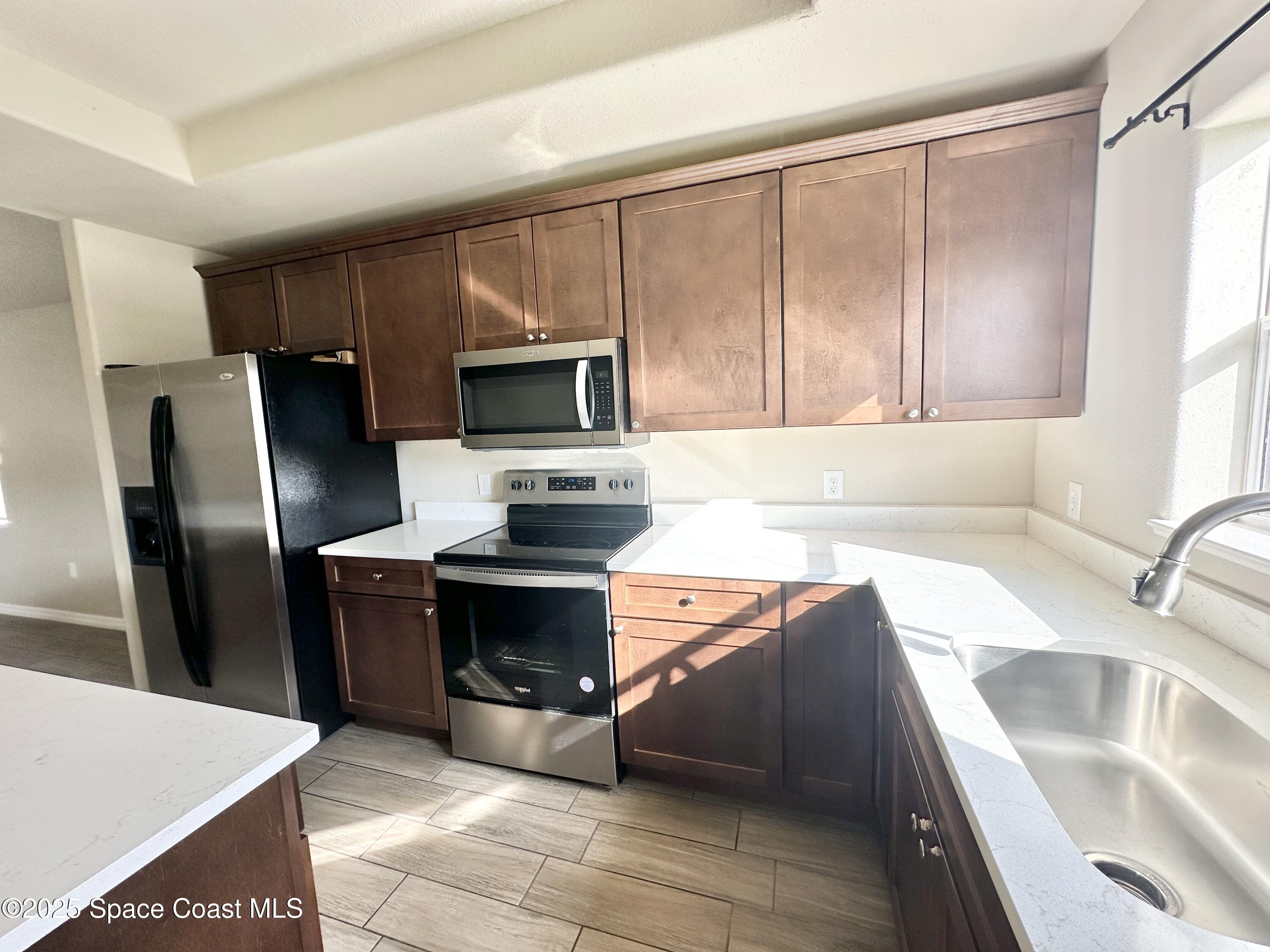 449 Alison Street Titusville, FL 32780 - Photo 7 of 22 a kitchen with stainless steel appliances granite countertop a sink a stove and a refrigerator