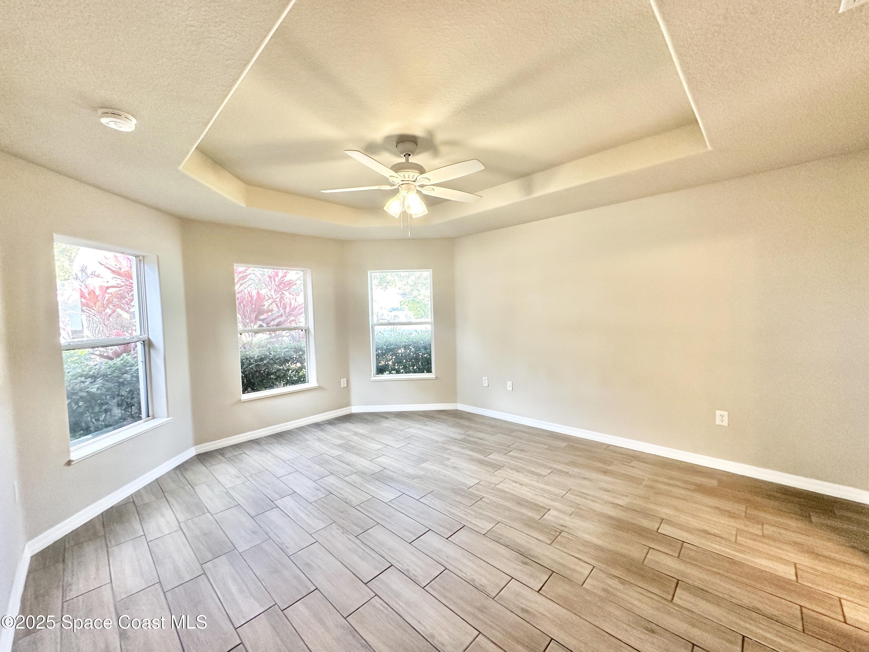 449 Alison Street Titusville, FL 32780 - Photo 10 of 22 an empty room with wooden floor and windows