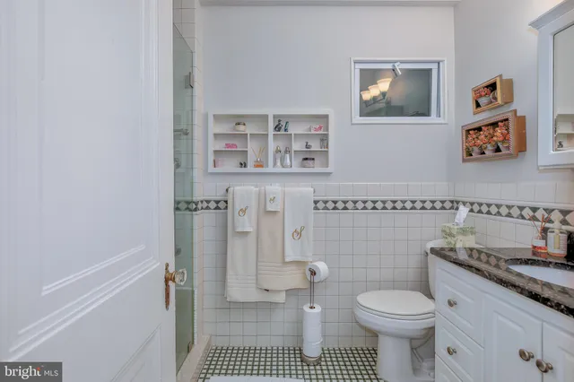 a bathroom with a granite countertop toilet sink and mirror