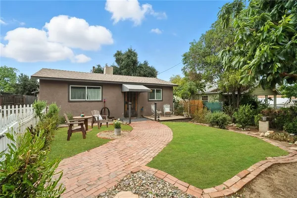 a view of a house with backyard sitting area and garden