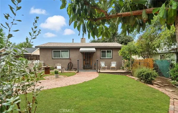 a view of a chair and table in backyard of the house