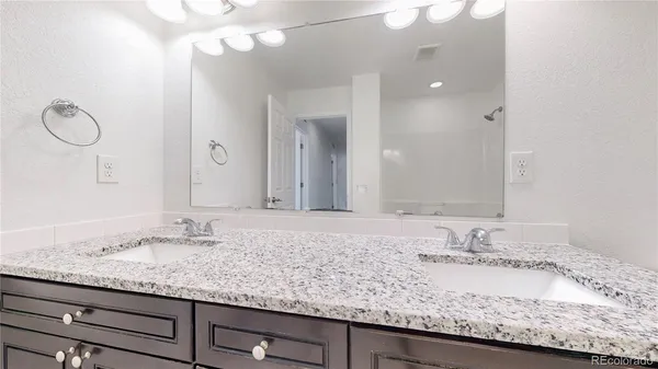 a bathroom with a granite countertop sink and a mirror
