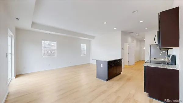 a large kitchen with stainless steel appliances granite countertop a large counter top and a wooden floor