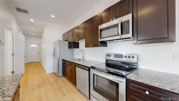 a kitchen with stainless steel appliances granite countertop a sink and a stove