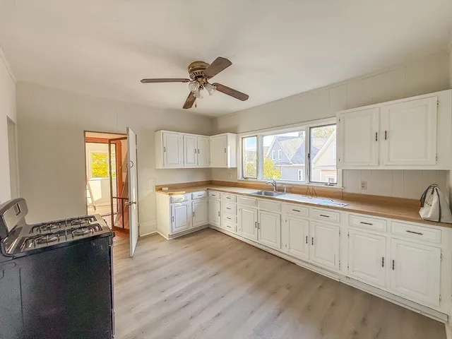 a large white kitchen with cabinets