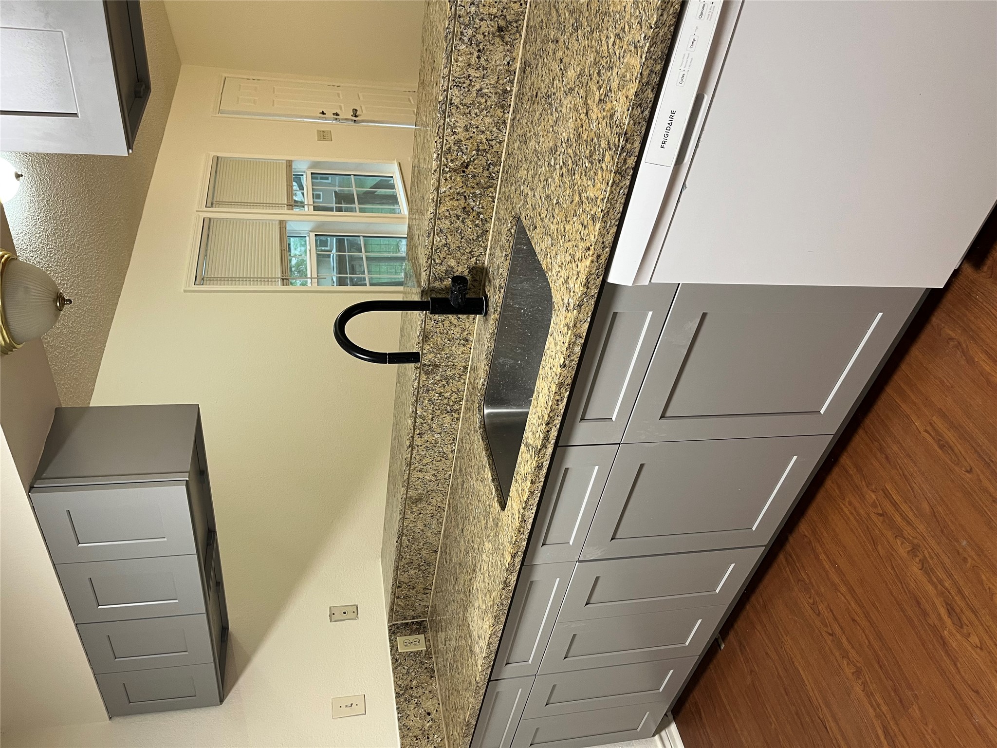 23393 Nameless Road, Unit 144 Leander, TX 78641 - Photo 9 of 23 Kitchen featuring a sink, stone countertops, gray cabinetry, dishwashing machine, and dark wood-style floors