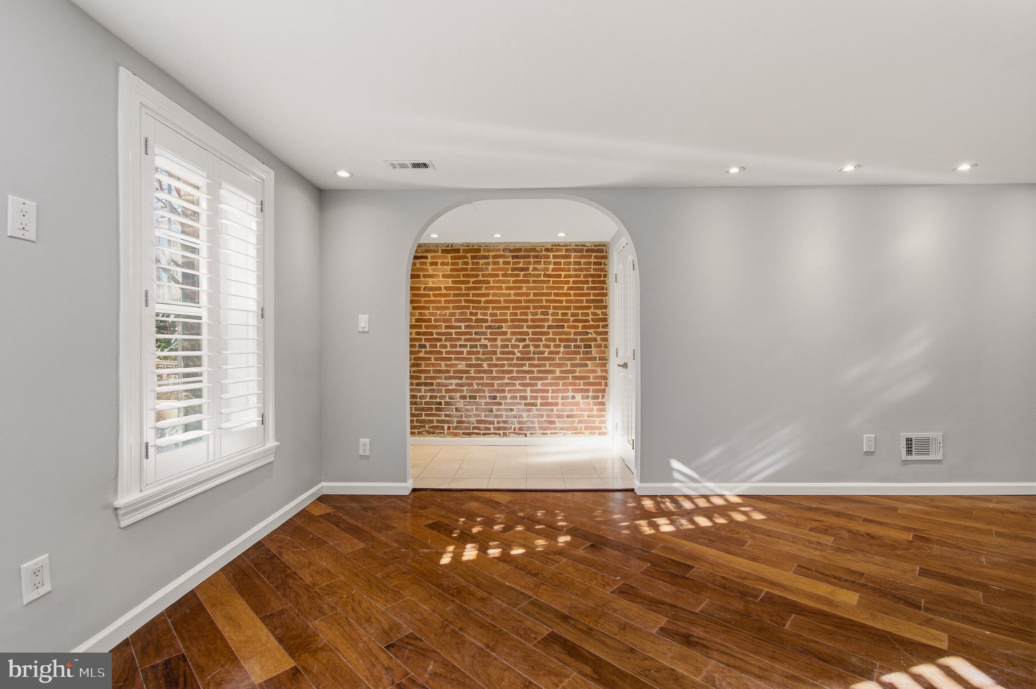 2117 S Street Northwest Washington, DC 20008 - Photo 19 of 63 a view of an empty room with window and wooden floor