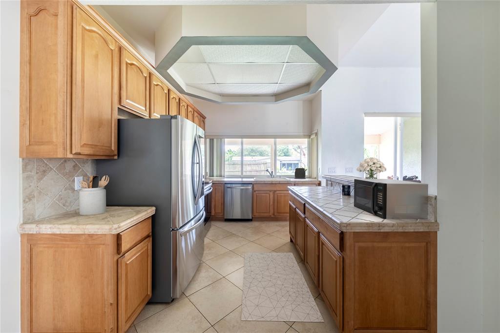 7205 Hibiscus Road Fort Pierce, FL 34951 - Photo 6 of 18 a kitchen with stainless steel appliances granite countertop a sink a refrigerator and a stove