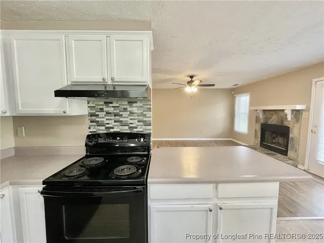 a kitchen with granite countertop a stove and a sink