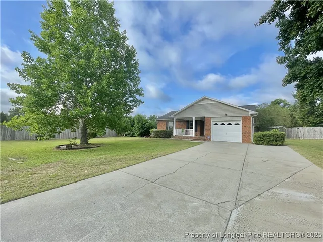 a front view of a house with a yard and trees
