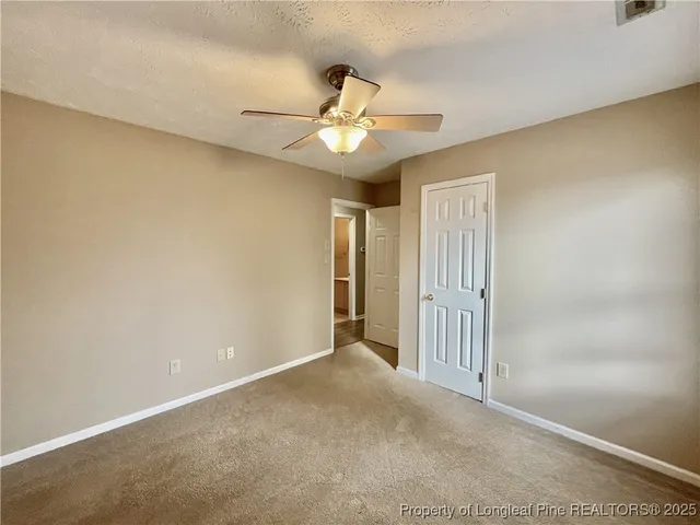 an empty room with a ceiling fan and a window