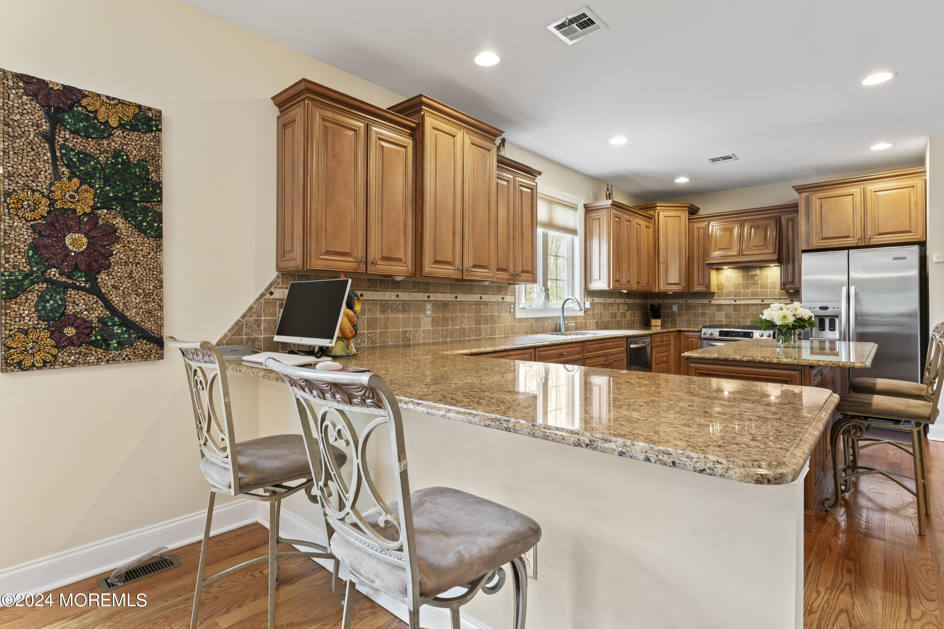 1588 West Front Street Lincroft, NJ 07738 - Photo 8 of 50 a kitchen with stainless steel appliances granite countertop a stove top oven a sink a dining table and chairs with wooden floor
