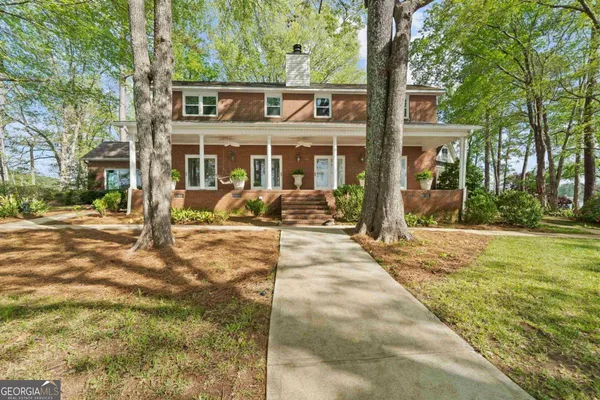 a view of house with swimming pool and outdoor seating