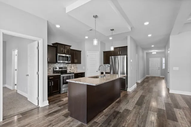 a kitchen with kitchen island a sink stainless steel appliances and cabinets