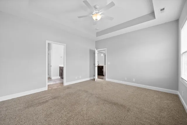 an empty room with closet and a ceiling fan