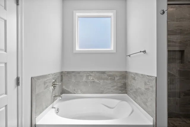 a bath tub sitting in a bathroom next to a window