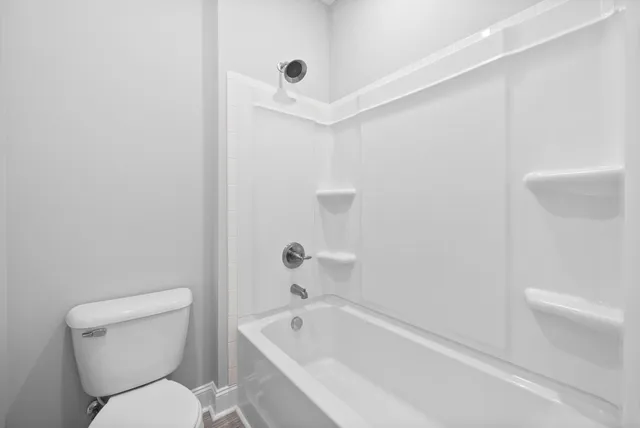 a white toilet sitting next to a bath tub