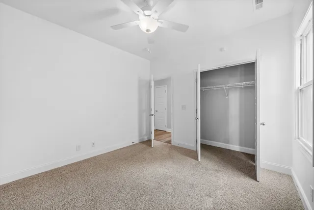 a view of an empty room with a ceiling fan