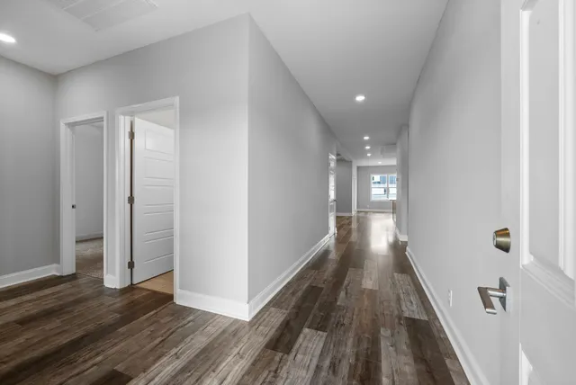 a view of a hallway with wooden floor and staircase