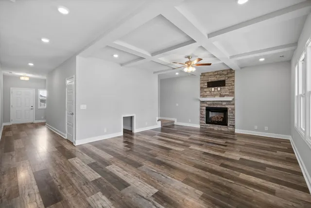 a view of empty room with wooden floor fireplace and window