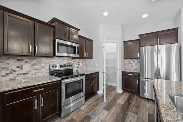 a kitchen with stainless steel appliances granite countertop a refrigerator stove a sink and dishwasher