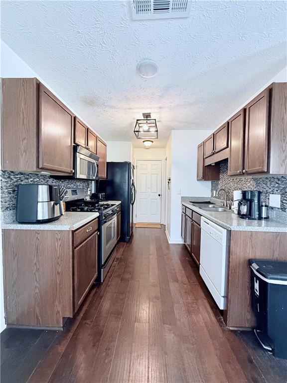 5705 Mountain Top Place Cumming, GA 30041 - Photo 6 of 10 a kitchen with stainless steel appliances granite countertop a stove top oven a sink dishwasher and a microwave oven on the wooden floor