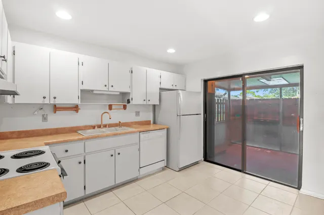 a kitchen with white cabinets and white appliances