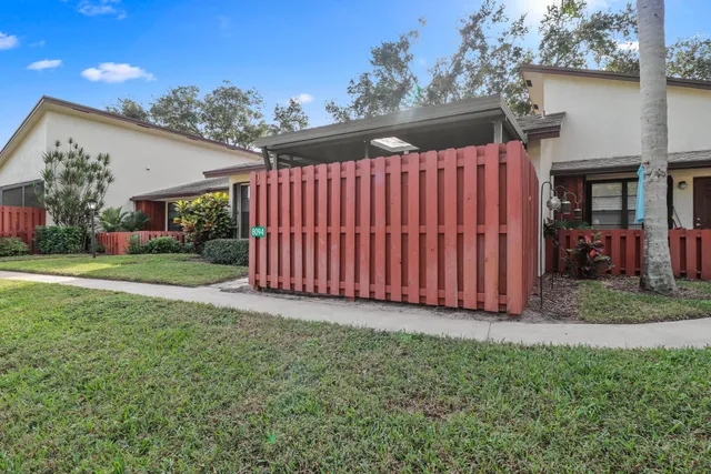a view of a backyard with plants and brick wall