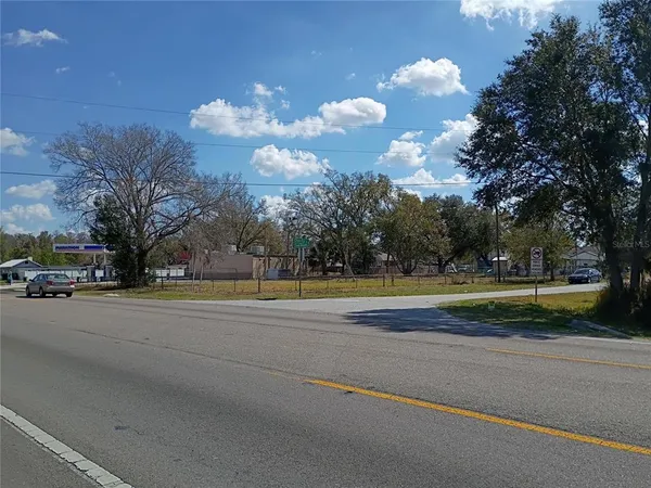a view of a house with a big yard and a large tree